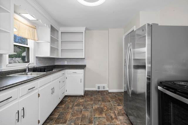 kitchen featuring sink, dark tile patterned floors, tasteful backsplash, electric stove, and white cabinets