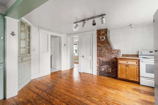 21 Chapel St Unit 21, Newburyport, MA 01950 - kitchen with electric stove, brown cabinetry, light wood-style floors, and rail lighting
