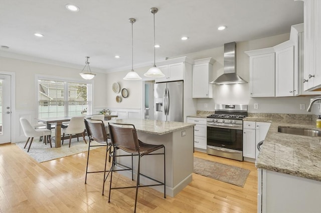 80 Edgemere Ave Unit 80, Northbridge, MA 01588 - kitchen featuring stainless steel appliances, wall chimney range hood, crown molding, a kitchen island, and white cabinets