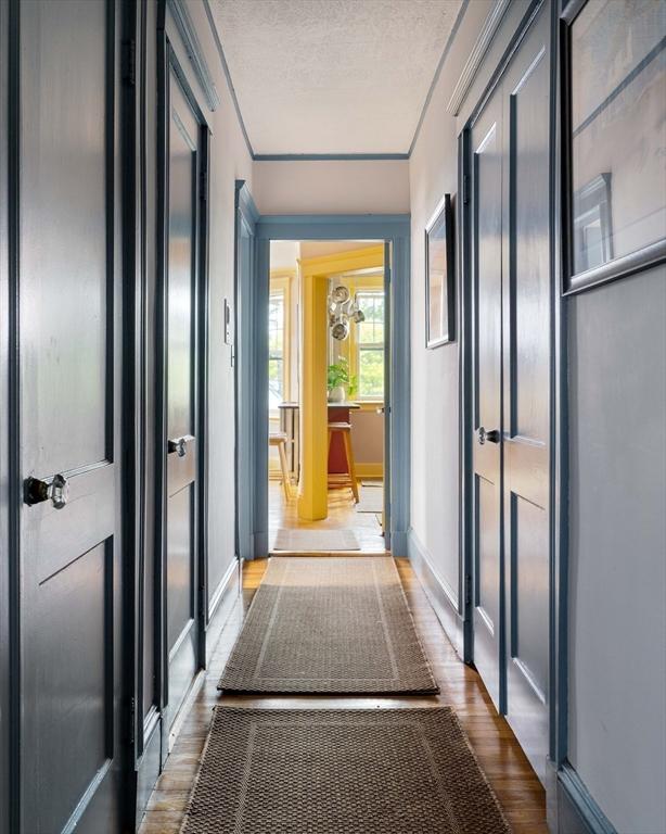 3 Newport Rd Unit 8, Cambridge, MA 02140 - hall featuring wood finished floors, a textured ceiling, and ornamental molding