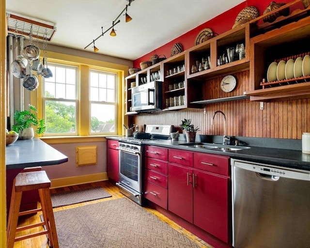 3 Newport Rd Unit 8, Cambridge, MA 02140 - kitchen with red cabinets, stainless steel appliances, light wood-type flooring, track lighting, and open shelves
