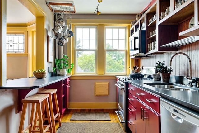 3 Newport Rd Unit 8, Cambridge, MA 02140 - kitchen with stainless steel appliances, light wood-style floors, plenty of natural light, and red cabinets