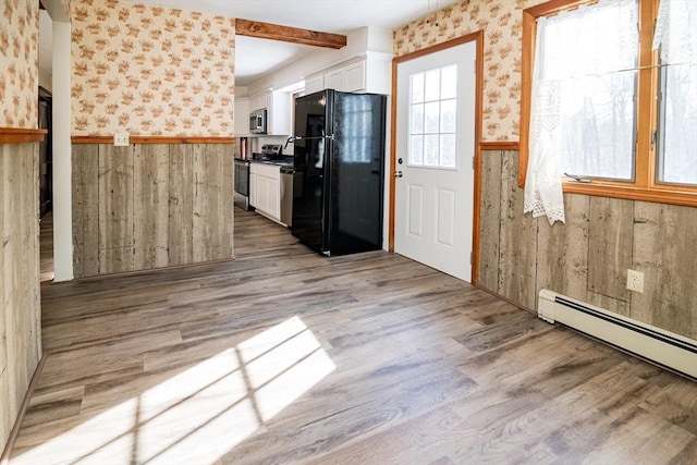 interior space featuring stainless steel appliances, white cabinetry, and light hardwood / wood-style floors