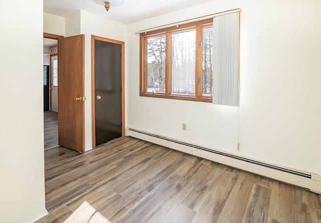 unfurnished bedroom featuring a baseboard radiator, a closet, and light wood-type flooring