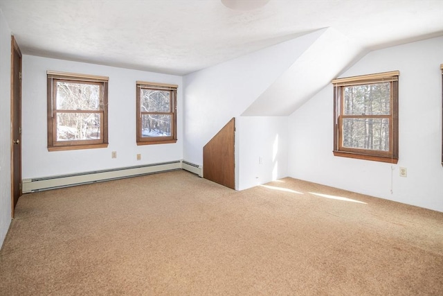 bonus room featuring lofted ceiling, a baseboard heating unit, plenty of natural light, and light colored carpet