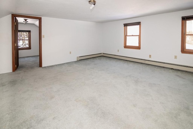 carpeted spare room featuring lofted ceiling and a baseboard heating unit