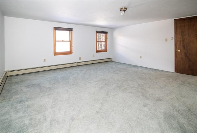 carpeted empty room featuring a baseboard heating unit