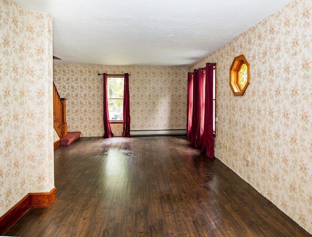 unfurnished room featuring dark wood-type flooring and a baseboard radiator