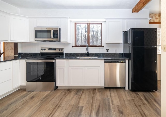 kitchen with stainless steel appliances, sink, and white cabinets