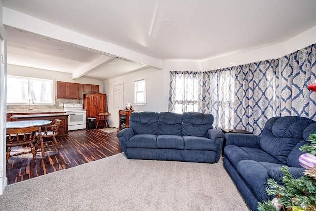 carpeted living room featuring beamed ceiling