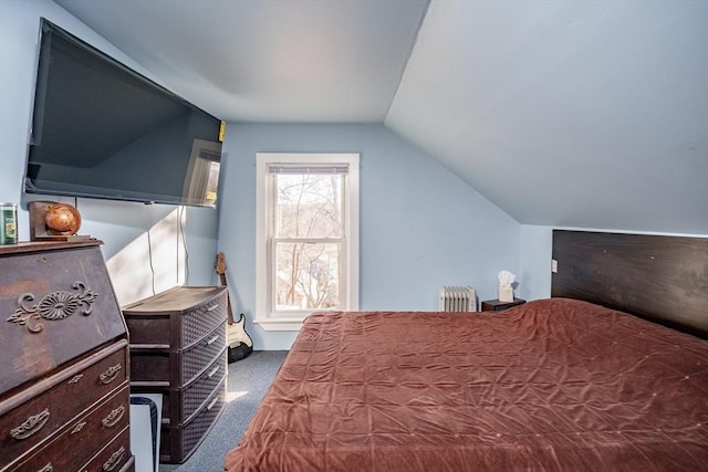 bedroom with radiator, dark carpet, and lofted ceiling