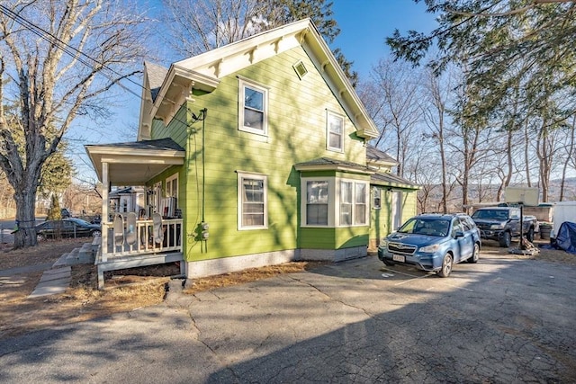 view of side of home featuring covered porch