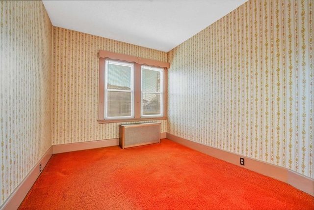 carpeted spare room with radiator, wallpapered walls, and baseboards