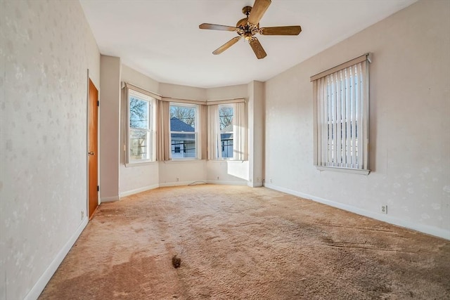 unfurnished room featuring a ceiling fan, baseboards, and carpet floors