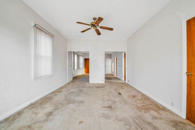 unfurnished bedroom with a ceiling fan, carpet, and baseboards