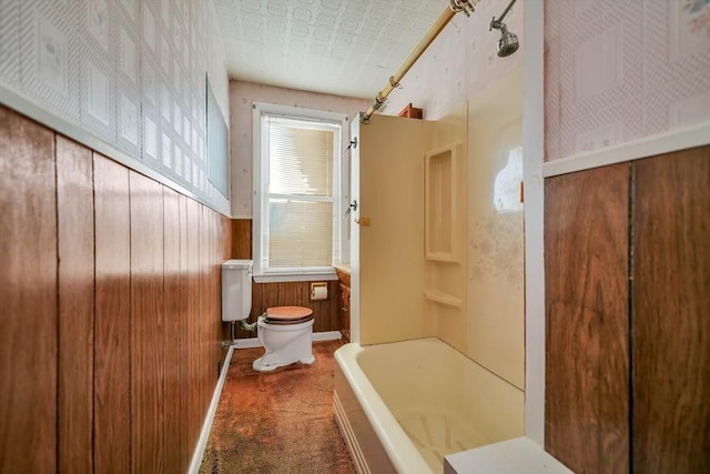 full bathroom with an ornate ceiling, toilet, wooden walls, and shower / tub combination