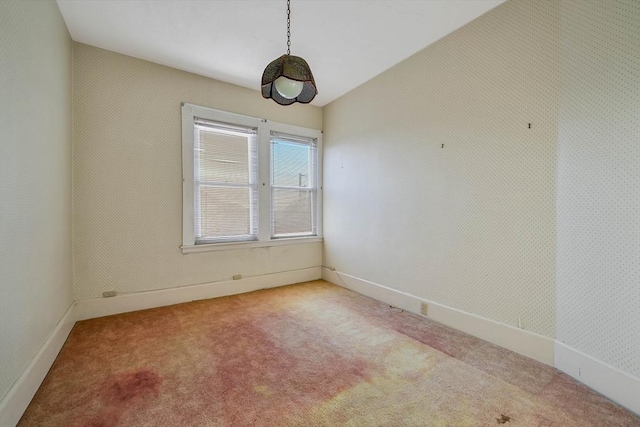 carpeted spare room with baseboards