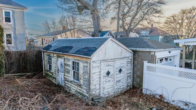 garage featuring fence and a shed