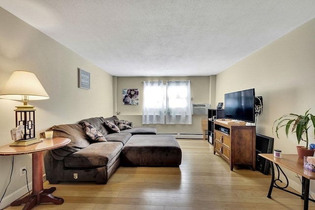 living room with baseboard heating, light hardwood / wood-style floors, and a textured ceiling