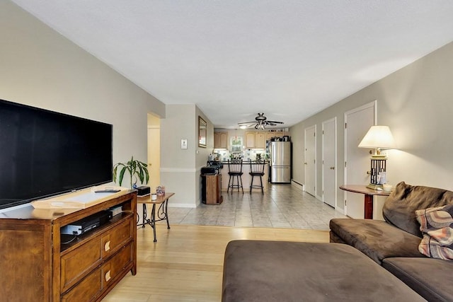 living room featuring ceiling fan and light hardwood / wood-style floors