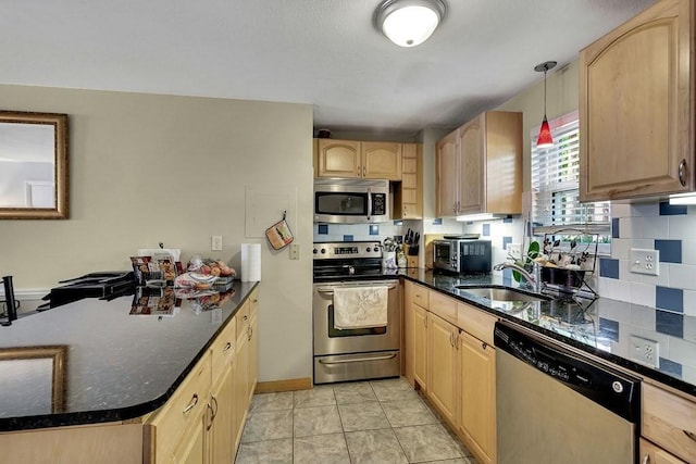 kitchen with decorative backsplash, light brown cabinetry, stainless steel appliances, sink, and decorative light fixtures