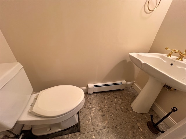 bathroom featuring baseboard heating and toilet