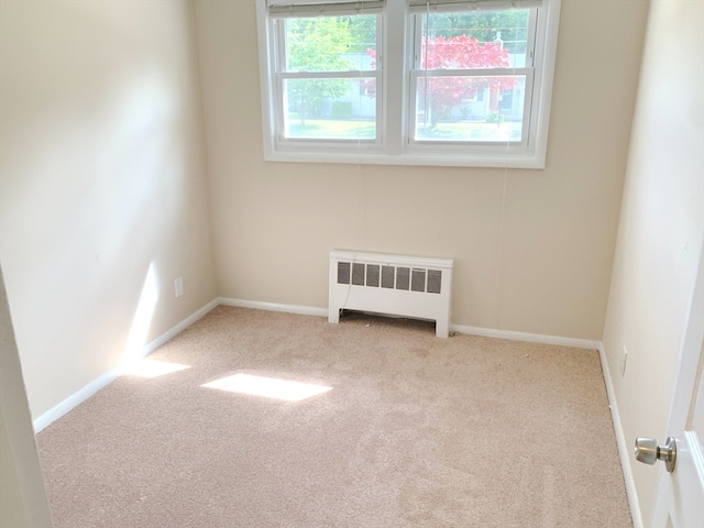 carpeted empty room with radiator heating unit