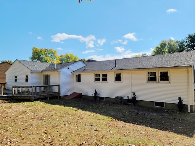 back of property with central AC, a wooden deck, and a yard