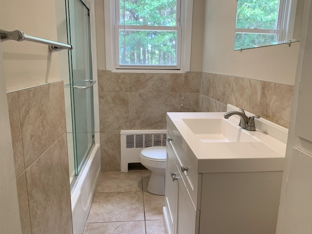 full bathroom with vanity, toilet, radiator heating unit, and a wealth of natural light