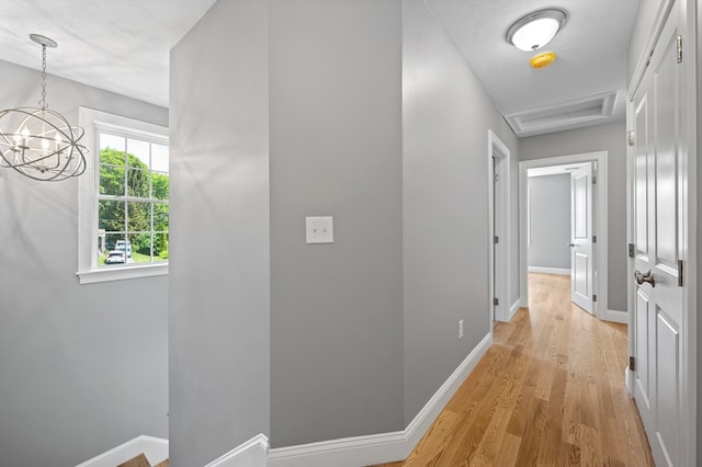233 W Mountain St, Worcester, MA 01606 - corridor featuring light wood-style flooring, a chandelier, baseboards, and attic access