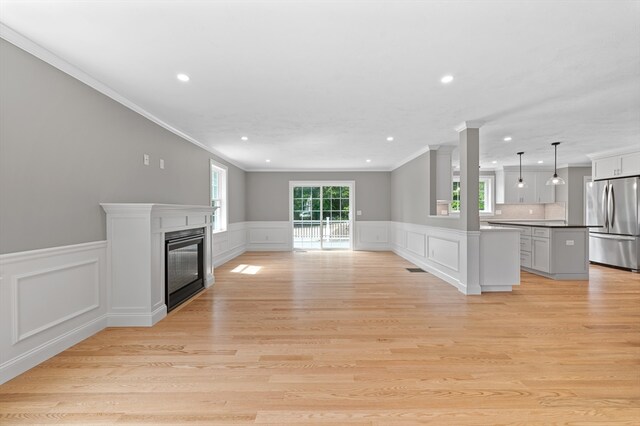 233 W Mountain St, Worcester, MA 01606 - unfurnished living room with crown molding, recessed lighting, a glass covered fireplace, light wood-style floors, and wainscoting