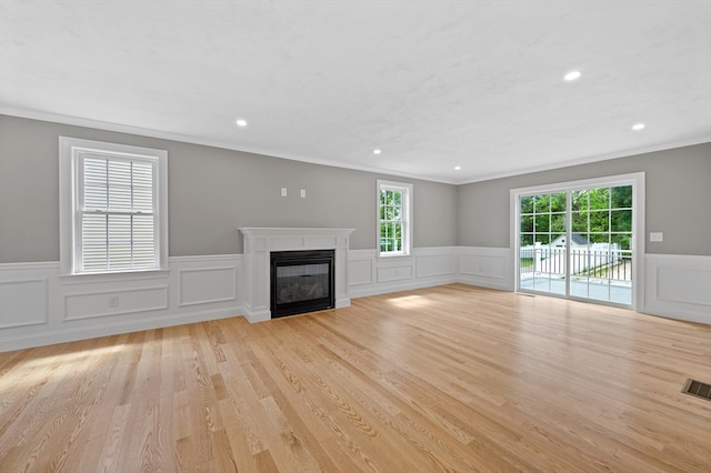 233 W Mountain St, Worcester, MA 01606 - unfurnished living room featuring ornamental molding, a glass covered fireplace, wainscoting, recessed lighting, and light wood-style floors