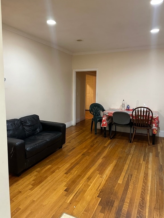 living room featuring crown molding and light hardwood / wood-style flooring