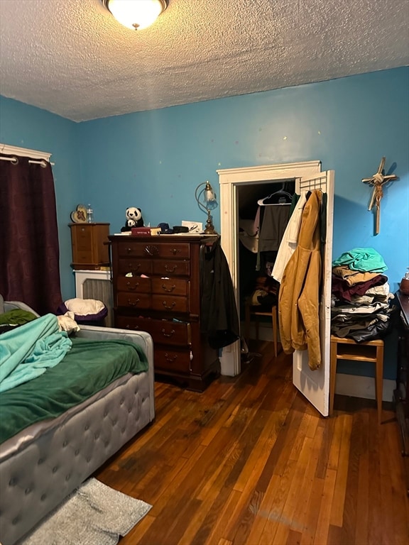 bedroom with dark hardwood / wood-style flooring and a textured ceiling