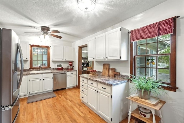 2 Pierce St, Agawam, MA 01030 - kitchen with appliances with stainless steel finishes, white cabinets, light wood finished floors, a ceiling fan, and a textured ceiling