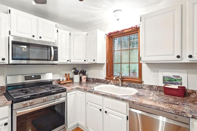 2 Pierce St, Agawam, MA 01030 - kitchen featuring appliances with stainless steel finishes, white cabinetry, and a textured ceiling