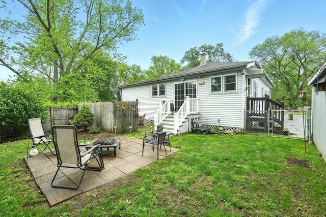 2 Pierce St, Agawam, MA 01030 - rear view of property featuring an outdoor fire pit, a chimney, a fenced backyard, and a patio area