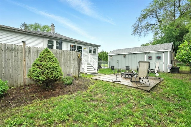 2 Pierce St, Agawam, MA 01030 - back of property featuring a fire pit, a fenced backyard, a patio, an outbuilding, and a chimney