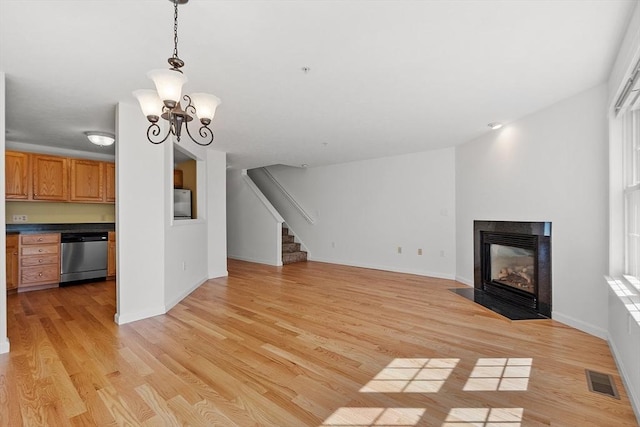 98 Caspian Way Unit 98, Fitchburg, MA 01420 - unfurnished living room featuring a multi sided fireplace, visible vents, light wood finished floors, and stairs