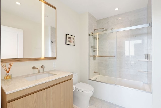 full bathroom featuring enclosed tub / shower combo, vanity, and toilet