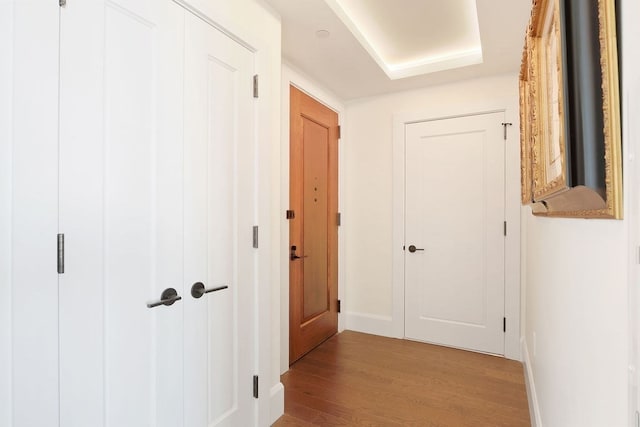 corridor with hardwood / wood-style flooring