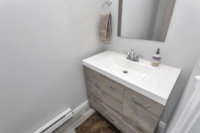 340 Dale St Unit A, Chicopee, MA 01020 - bathroom with baseboard heating, baseboards, wood finished floors, and vanity