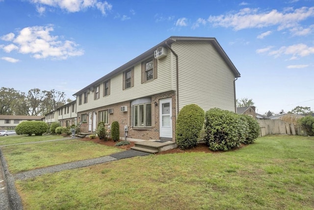 340 Dale St Unit A, Chicopee, MA 01020 - view of front facade featuring fence, an AC wall unit, brick siding, and a front yard
