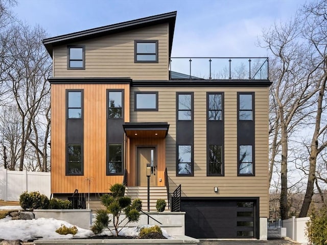 contemporary house featuring a garage and fence