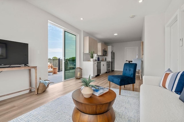 living room with light wood-style flooring and recessed lighting