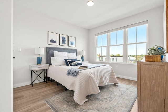 bedroom with light wood-style flooring and baseboards