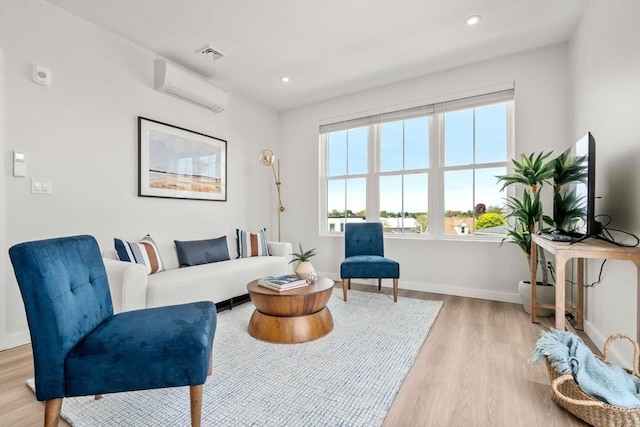 sitting room with recessed lighting, a wall unit AC, baseboards, visible vents, and light wood-type flooring