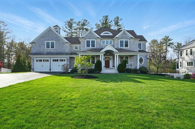 view of front of property featuring an attached garage, a front lawn, and driveway