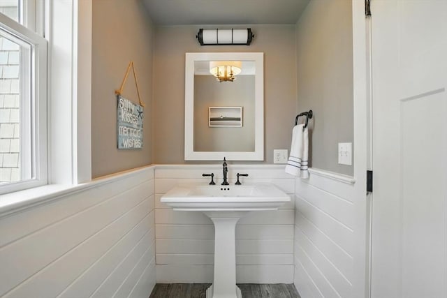 bathroom featuring an inviting chandelier and a wainscoted wall