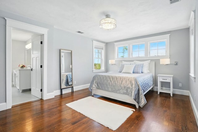 bedroom featuring visible vents, baseboards, wood finished floors, and an inviting chandelier